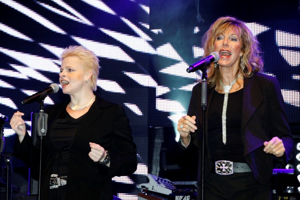 Zwei Background Sängerinnen des Doubles in schwarzen Klamotten vor Mikrofonen.