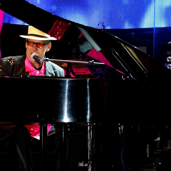 Eine Collage des Elton John Doubles mit zwei Background Sängerinnen.
