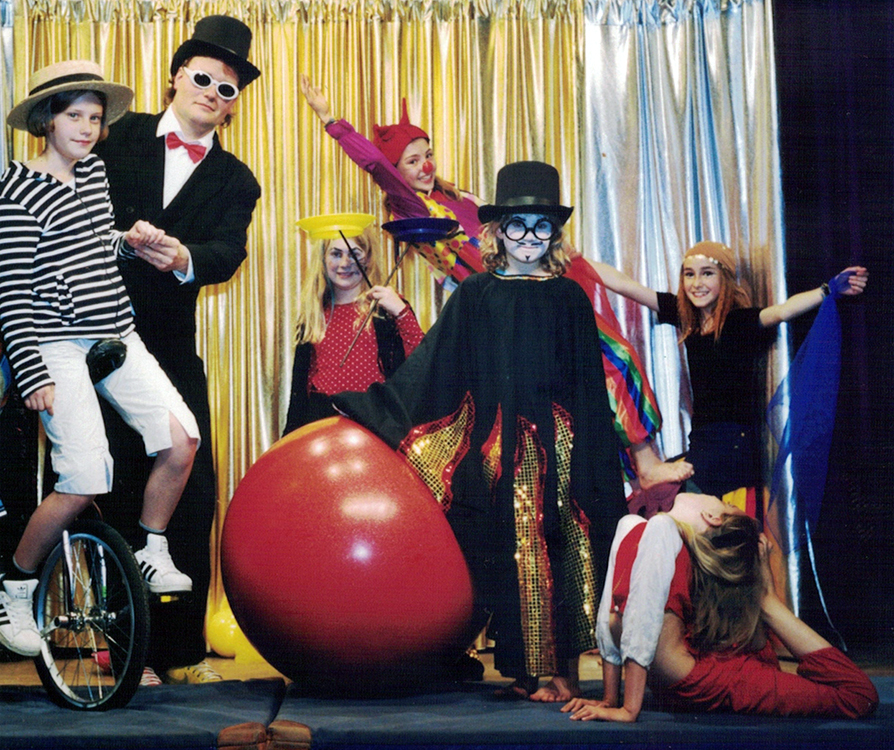 Der Zirkus Direktor mit mehreren Kindern auf der Bühne.